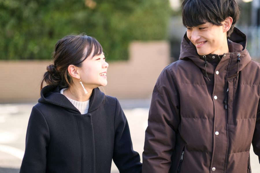 Young Asian couple walking around their house in residential area